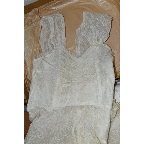 581 - A BOXED WEDDING DRESS AND THREE BABY'S GOWNS, the cream net covered wedding dress approximately size... 