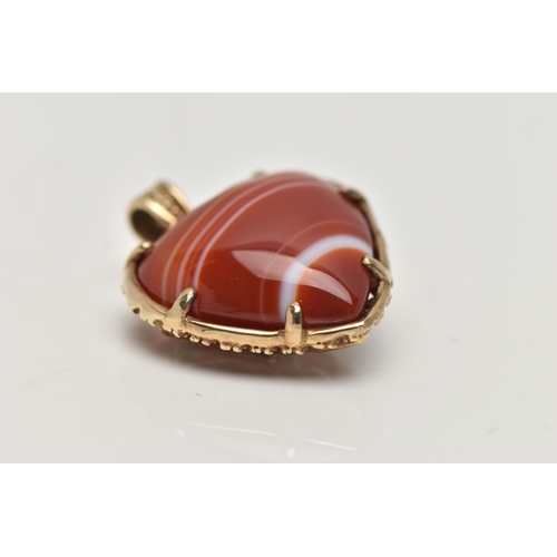 131 - A 9CT GOLD BANDED AGATE HEART PENDANT, polished orange and white agate heart within a floral detaile... 