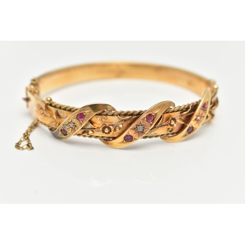 10 - AN EARLY 20TH CENTURY GOLD BANGLE, a hinged bangle designed with foliage and wire work detail, set w... 