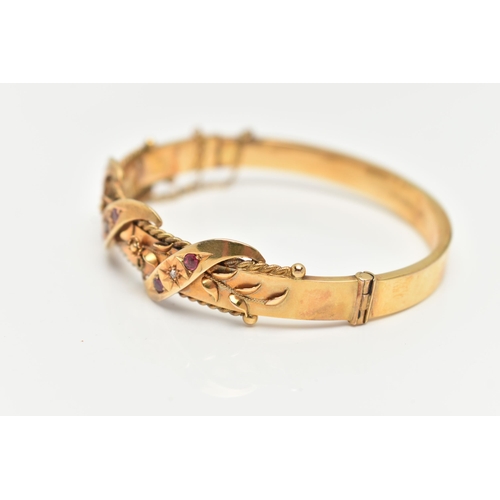 10 - AN EARLY 20TH CENTURY GOLD BANGLE, a hinged bangle designed with foliage and wire work detail, set w... 