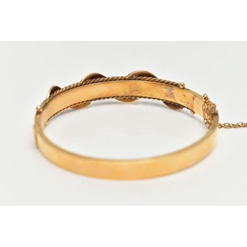 10 - AN EARLY 20TH CENTURY GOLD BANGLE, a hinged bangle designed with foliage and wire work detail, set w... 