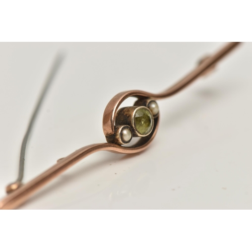 128 - A ROSE METAL GEM SET BAR BROOCH, set with a central circular cut peridot, flanked with seed pearls, ... 