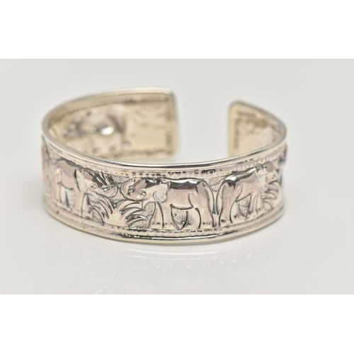 20 - A SILVER CUFF BANGLE, depicting a row of embossed elephants, hallmarked Birmingham, approximate gros... 