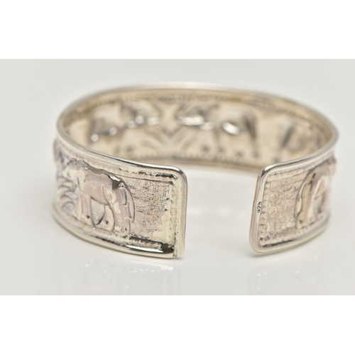 20 - A SILVER CUFF BANGLE, depicting a row of embossed elephants, hallmarked Birmingham, approximate gros... 