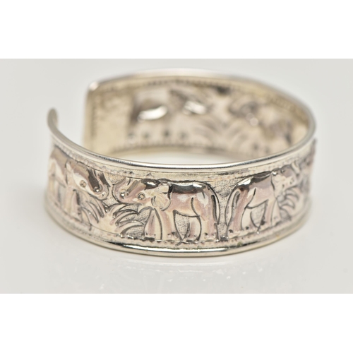 20 - A SILVER CUFF BANGLE, depicting a row of embossed elephants, hallmarked Birmingham, approximate gros... 