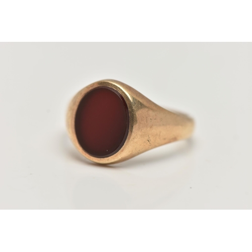 37 - A GENTS 9CT GOLD SIGNET RING, of an oval form set with a polished oval carnelian inlay, to a polishe... 