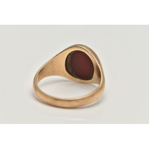 37 - A GENTS 9CT GOLD SIGNET RING, of an oval form set with a polished oval carnelian inlay, to a polishe... 