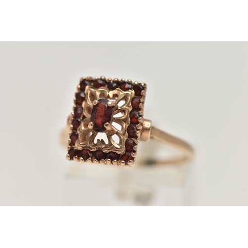 47 - A 9CT GOLD GARNET DRESS RING, rectangular form, set with a principle oval cut garnet and eighteen ci... 