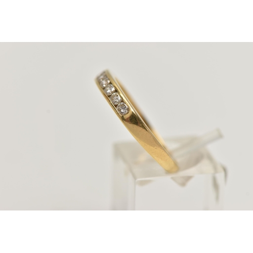 98 - AN 18CT GOLD DIAMOND BAND RING, seven round brilliant cut diamonds, channel set in yellow gold, appr... 