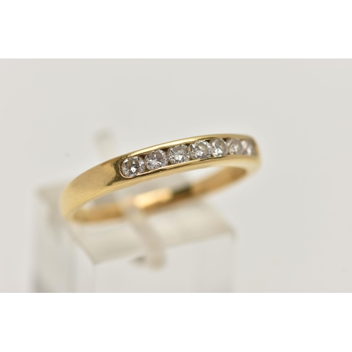 98 - AN 18CT GOLD DIAMOND BAND RING, seven round brilliant cut diamonds, channel set in yellow gold, appr... 