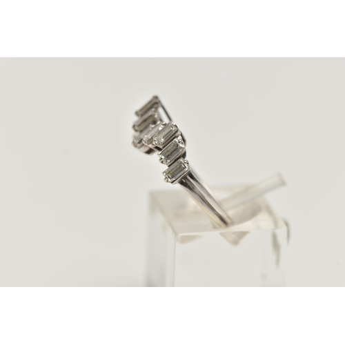 12 - AN 18CT WHITE GOLD DIAMOND RING, designed with a wavy row of nine baguette cut diamonds, each in a t... 