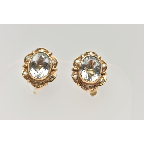 15 - A PAIR OF NON-PIERCED, YELLOW METAL GEM SET EARRINGS, each of an oval outline, set with an oval cut ... 