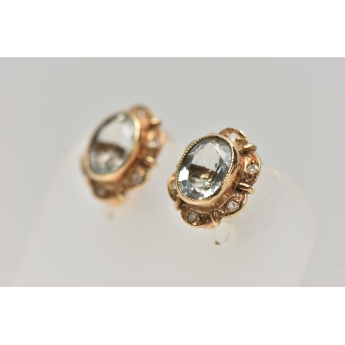 15 - A PAIR OF NON-PIERCED, YELLOW METAL GEM SET EARRINGS, each of an oval outline, set with an oval cut ... 