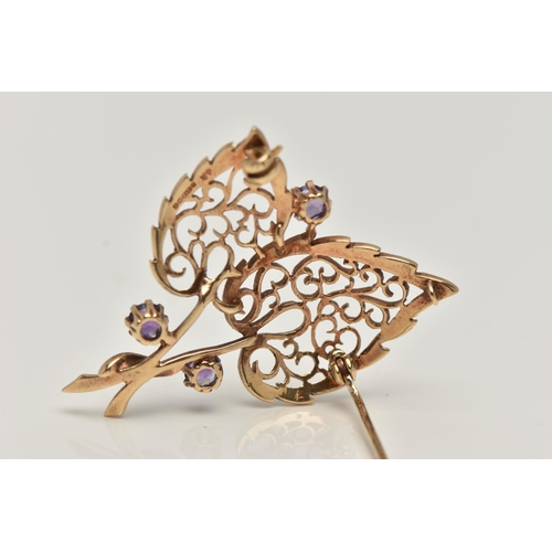 17 - A 9CT GOLD, AMETHYST BROOCH, in the form of two open work leaves, set with three circular cut amethy... 