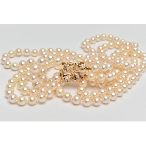 2 - A CULTURED PEARL NECKLACE, designed with three strands of individually knotted cream pearls with a p... 