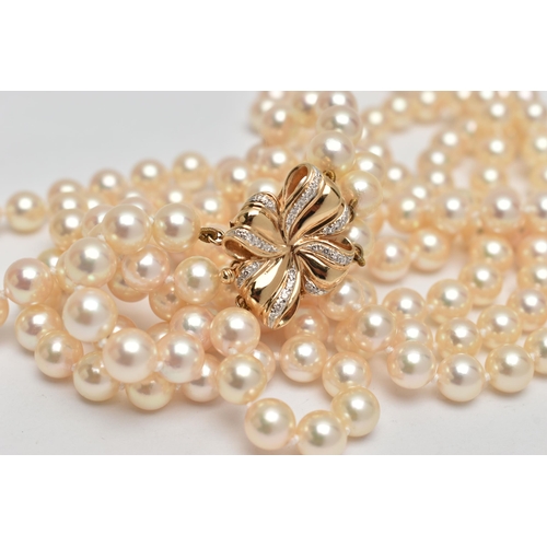 2 - A CULTURED PEARL NECKLACE, designed with three strands of individually knotted cream pearls with a p... 