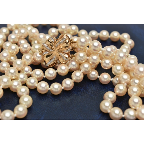 2 - A CULTURED PEARL NECKLACE, designed with three strands of individually knotted cream pearls with a p... 