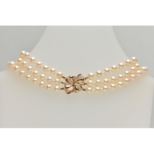 2 - A CULTURED PEARL NECKLACE, designed with three strands of individually knotted cream pearls with a p... 