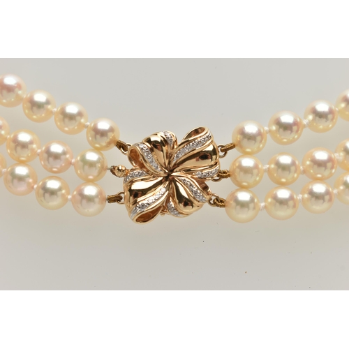 2 - A CULTURED PEARL NECKLACE, designed with three strands of individually knotted cream pearls with a p... 