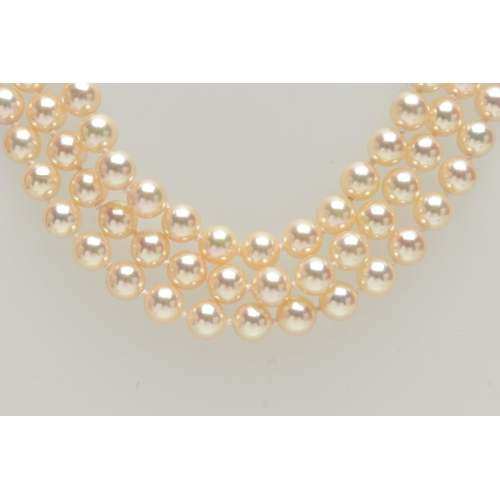 2 - A CULTURED PEARL NECKLACE, designed with three strands of individually knotted cream pearls with a p... 