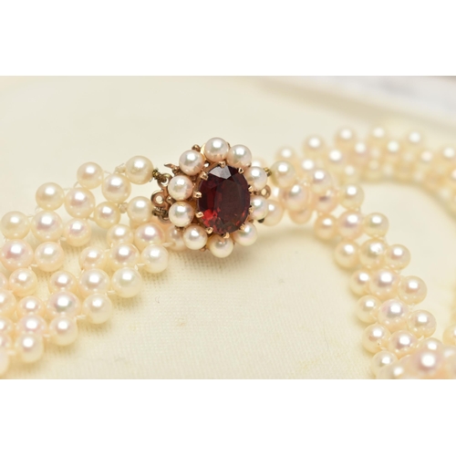 26 - A CULTURED PEARL CHOKER AND BRACELET, designed as a row of three cultured cream pearls with a pink h... 