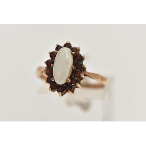 29 - A 9CT GOLD CLUSTER RING, of an oval form, set with a central opal cabochon, in a surround of circula... 