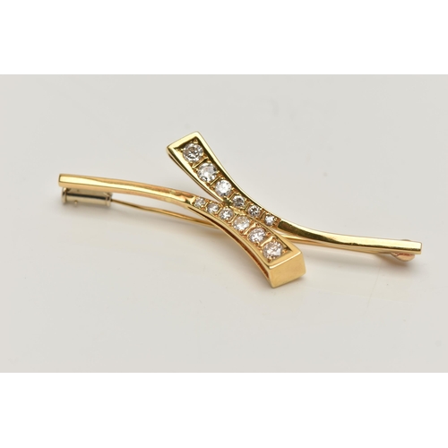 7 - AN 18CT GOLD DIAMOND BROOCH, cross over style bar brooch, set with two rows of graduated round brill... 