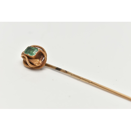 114 - A YELLOW METAL EMERALD AND COILED SNAKE STICK PIN, centring on an emerald cut emerald, in a claw set... 