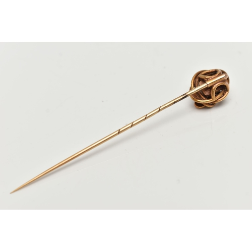 114 - A YELLOW METAL EMERALD AND COILED SNAKE STICK PIN, centring on an emerald cut emerald, in a claw set... 