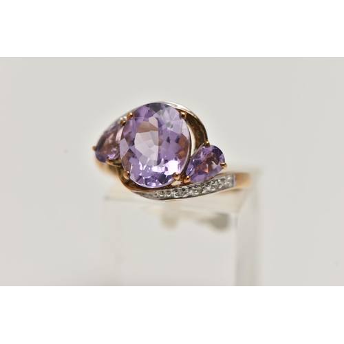 123 - AN AMETHYST AND DIAMOND RING, designed as an oval amethyst flanked by pear shape amethysts to the cr... 