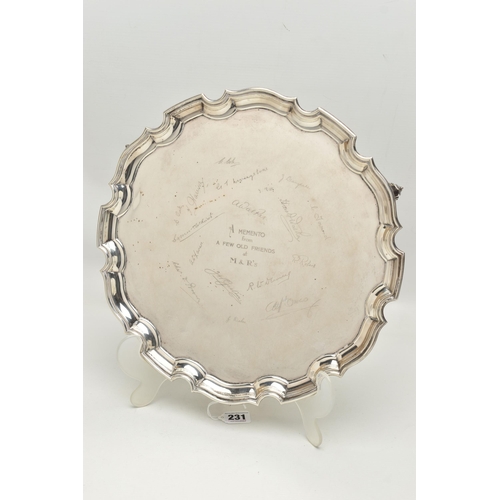 231 - AN EARLY 20TH CENTURY SILVER SALVER, circular form with wavy rim, raised on three scrolling feet, pe... 