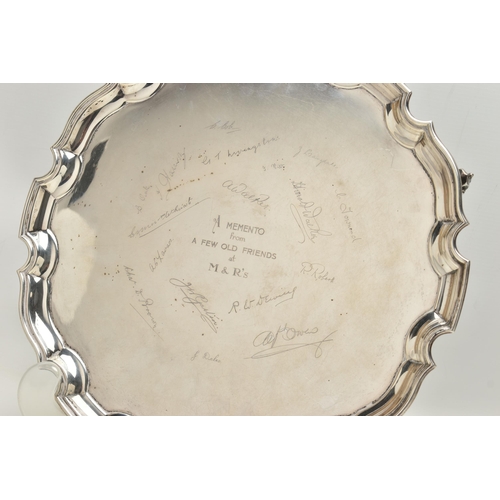 231 - AN EARLY 20TH CENTURY SILVER SALVER, circular form with wavy rim, raised on three scrolling feet, pe... 