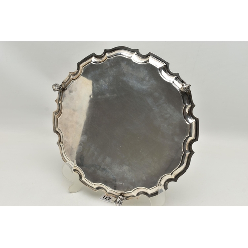 231 - AN EARLY 20TH CENTURY SILVER SALVER, circular form with wavy rim, raised on three scrolling feet, pe... 