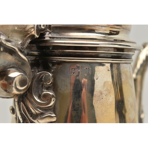 234 - A GEORGIAN SILVER COFFEE POT, tall polished pot with engraved family crest, leaf detail to the spout... 