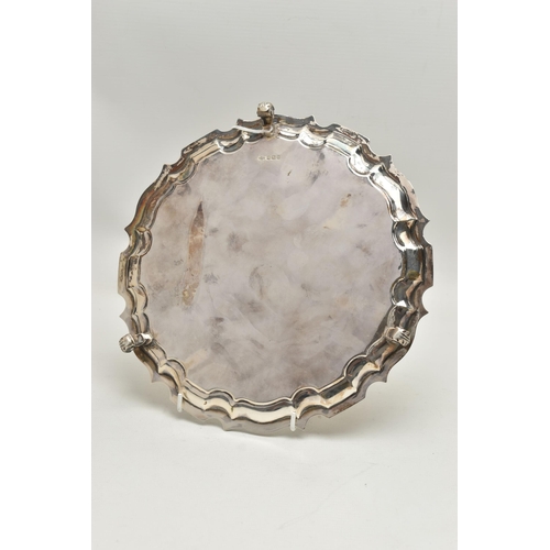 241 - A GEORGE V SILVER WAITER, circular form with wavy rim, raised on three scroll feet, personal engravi... 