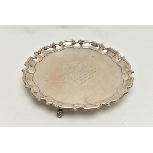 241 - A GEORGE V SILVER WAITER, circular form with wavy rim, raised on three scroll feet, personal engravi... 