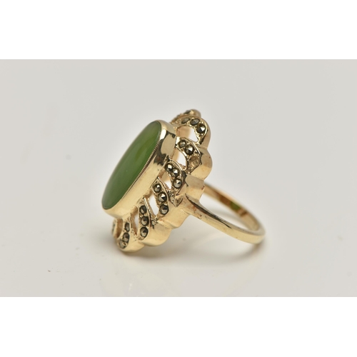 84 - A YELLOW METAL JADE DRESS RING, of a large oval form, set to the centre with an oval cut jade caboch... 