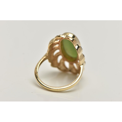 84 - A YELLOW METAL JADE DRESS RING, of a large oval form, set to the centre with an oval cut jade caboch... 