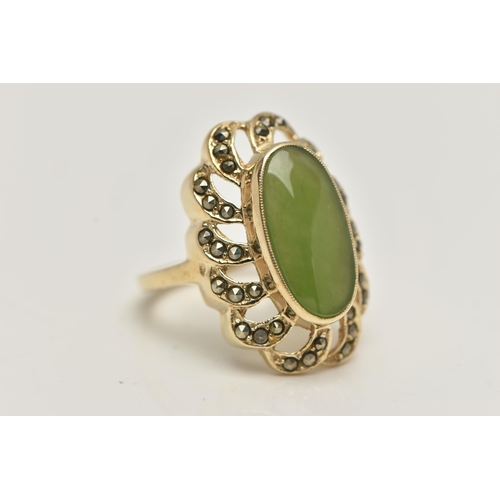 84 - A YELLOW METAL JADE DRESS RING, of a large oval form, set to the centre with an oval cut jade caboch... 