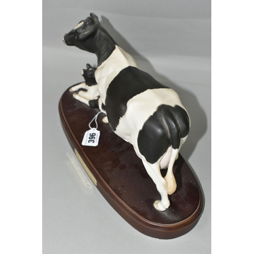 396 - A ROYAL DOULTON FRIESIAN COW AND CALF, standing on a wooden plinth, model no A2607/2690, height incl... 