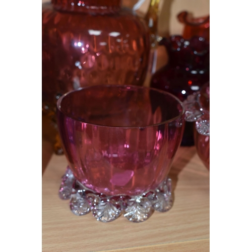 398 - A GROUP OF CRANBERRY GLASS, comprising a graduating clear to pink jug, with amber glass handle and t... 