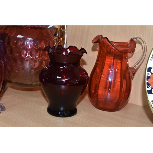 398 - A GROUP OF CRANBERRY GLASS, comprising a graduating clear to pink jug, with amber glass handle and t... 