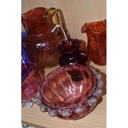 398 - A GROUP OF CRANBERRY GLASS, comprising a graduating clear to pink jug, with amber glass handle and t... 