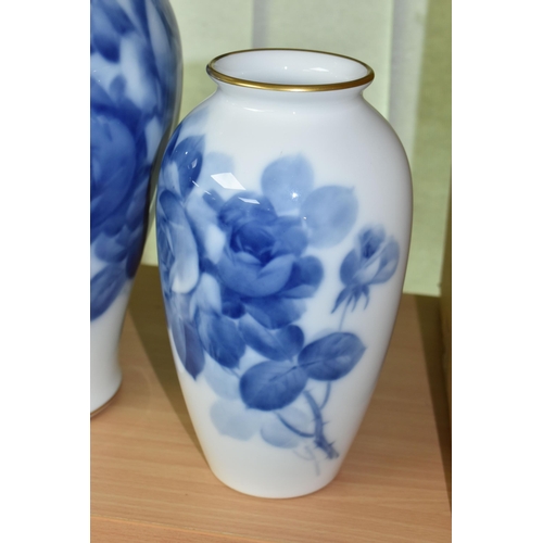 405 - THREE JAPANESE OKURA PORCELAIN VASES, decorated with blue roses on a white ground, heights 22cm, 23c... 