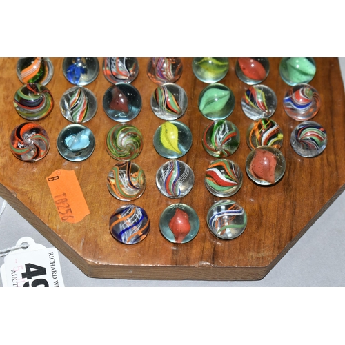 490 - A SOLITAIRE BOARD WITH VINTAGE/ANTIQUE MARBLES, the wooden board containing thirty three handmade ma... 