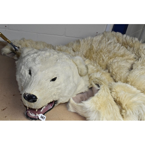 587 - TAXIDERMY IN THE FORM OF A  POLAR BEAR, glass eyes, nose damaged, wooden head, on a fabric lining (1... 