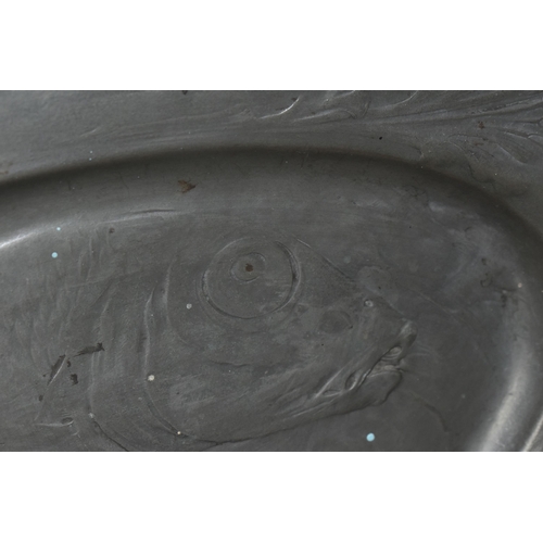 635 - A URANIA OF MAASTRICHT PEWTER SALVER, the central portion decorated with a carp in relief, the handl... 