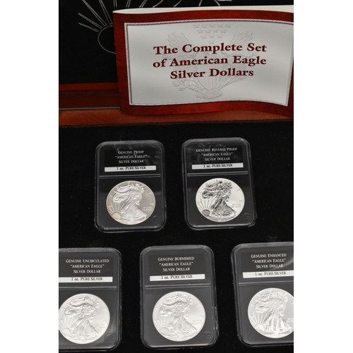 212 - A BOXED DISPLAY OF AMERICAN SILVER DOLLAR COINS, to include five different finishes genuine reverse ... 