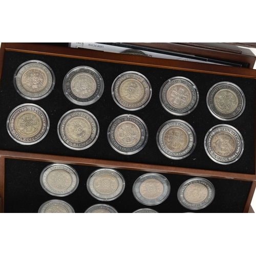 228 - A LARGE AND HEAVY BOX OF CASED UK COINAGE, to include the complete Shilling collection (58) 29 year ... 