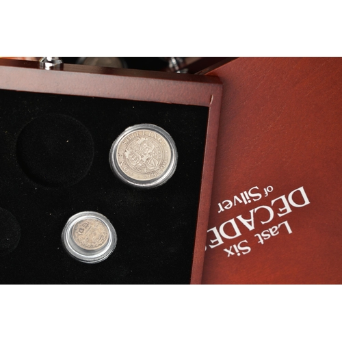 229 - A GLAZED DISPLAY BOX THREE DECADES of GEORGE V STAMP AND COIN SET, to include four trays of silver c... 